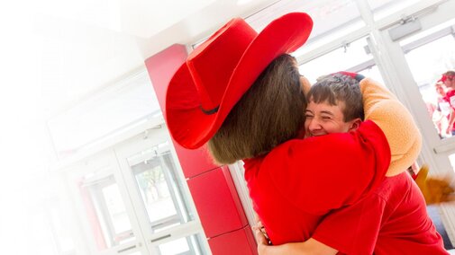Student hugging Herbie Husker
