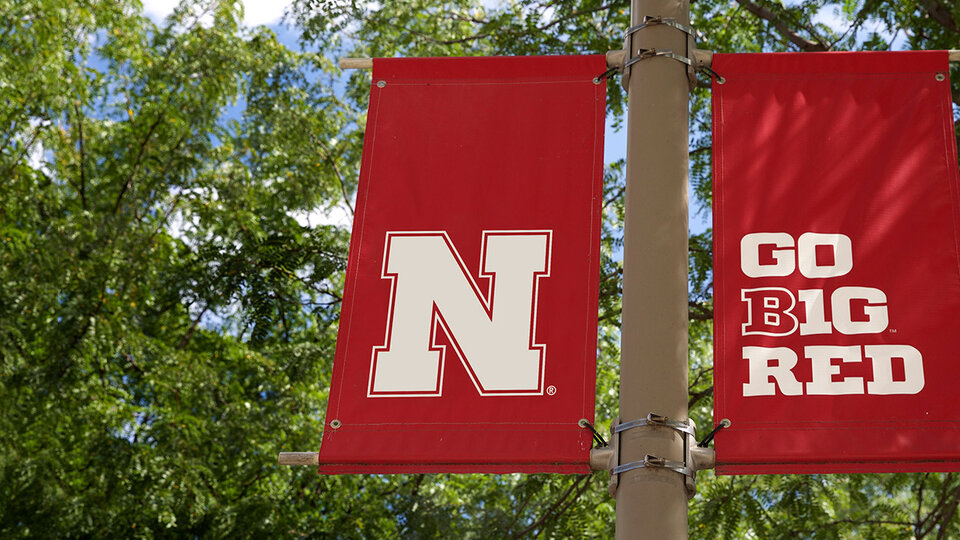 N logo flags hanging on pole on campus